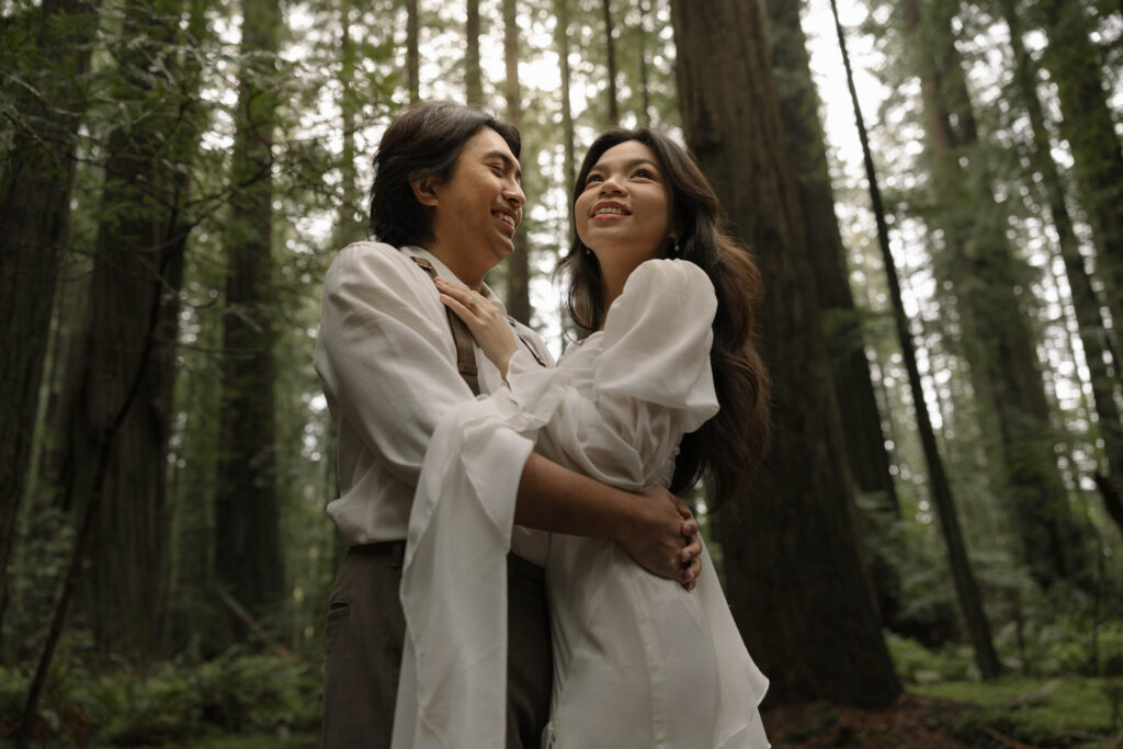 Couple waking beneath towering redwood trees along Avenue of the Giants during their Northern California elopement.